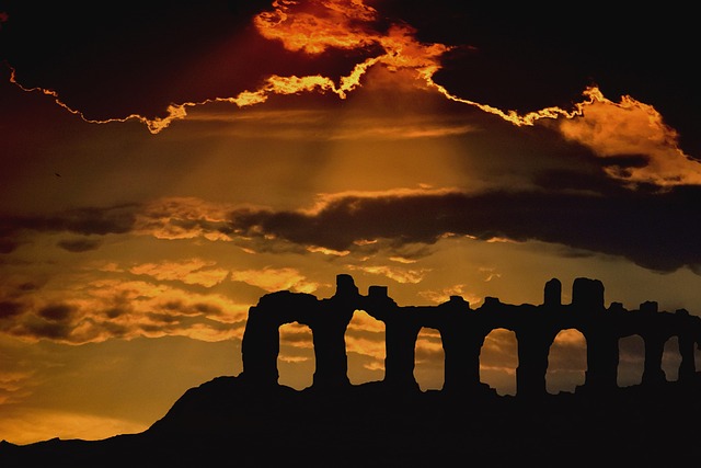 Ancient ruins silhouetted against a dramatic sunset