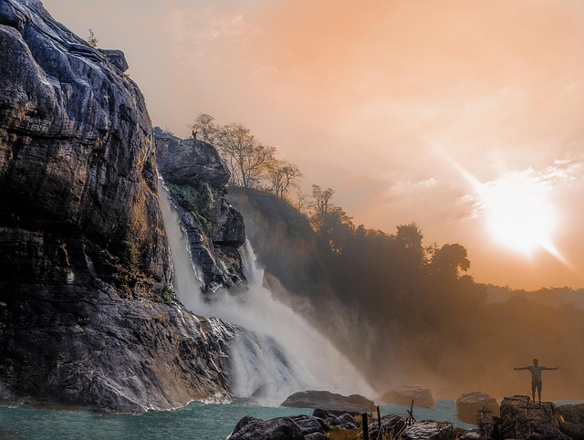 A traveler taking a photo of a breathtaking waterfall